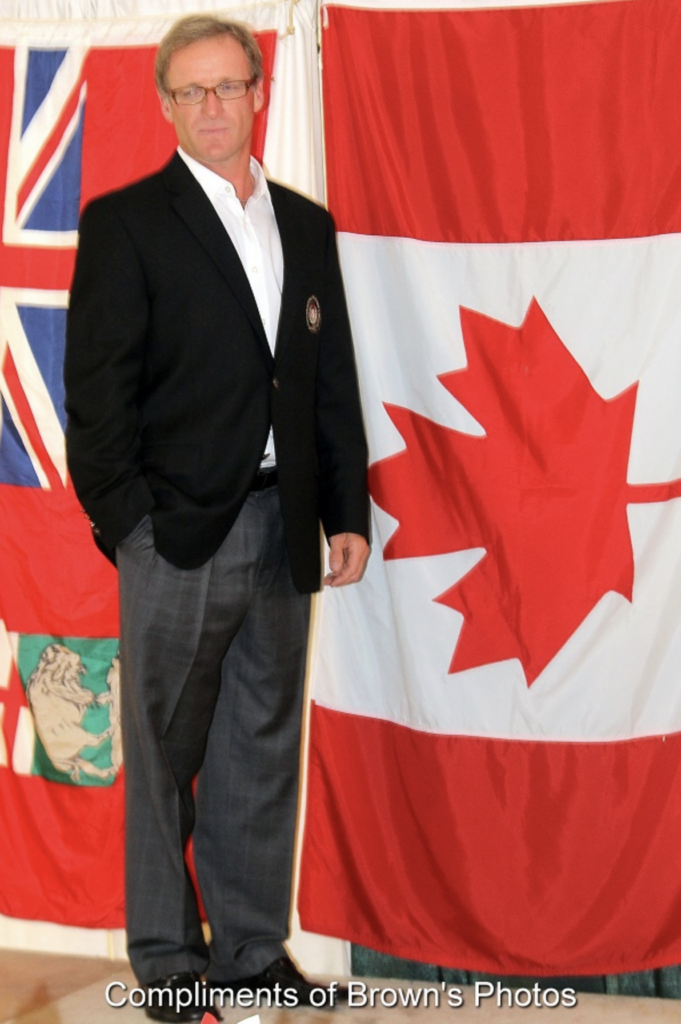 rheal-cormier-standing-in-front-of-canadian-flag